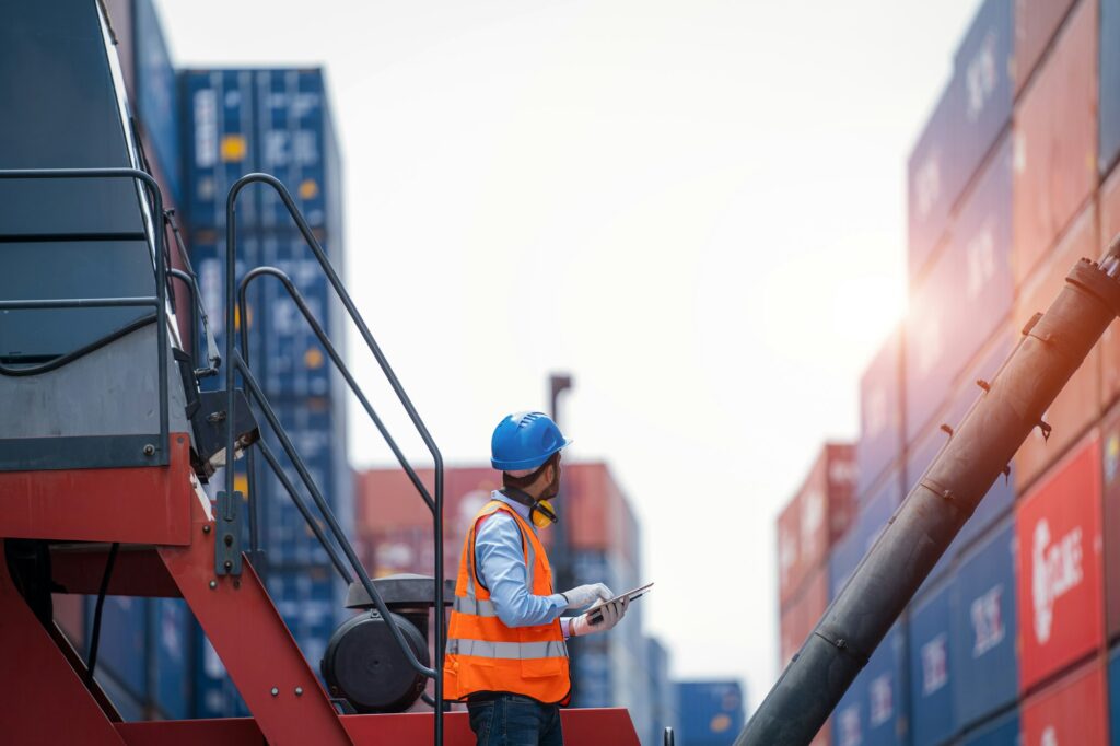 Professional container yard workers checking stock for loading in the container yard warehouse.